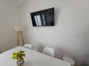 Habitación con mesa blanca y TV en la pared. en Departamento a estrenar en pleno centro de Salta 1 dormitorio en Salta
