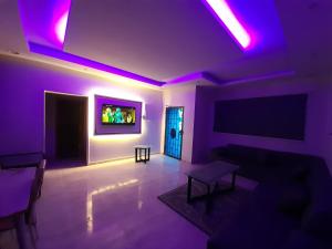 a living room with purple lighting and a couch at Red Sea Resort (Families Only) in Rayyis