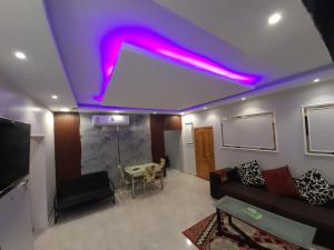 a living room with purple lights on the ceiling at Red Sea Resort (Families Only) in Rayyis