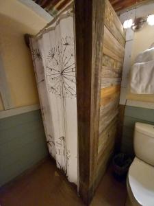 a bathroom with a toilet and a wooden door at Acorn Hideaways Canton Sweet Dreams for 2 in Canton