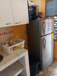 a kitchen with a stainless steel refrigerator and a table at La Casa De Lili in Olón