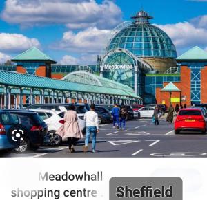 a building with cars parked in a parking lot at HILLTOP PLACE SUITES M1 J31 near PEAK DISTRICT 