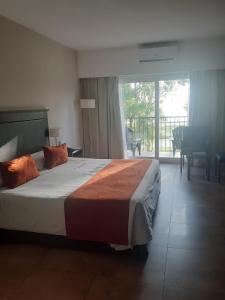 a hotel room with a bed and a balcony at Howard Johnson Chascomus in Chascomús