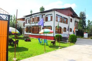 古尔马尔格Gulsitara Resorts-Gulmarg的房屋前面有椅子和遮阳伞