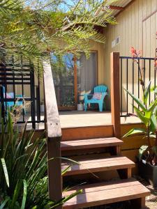 weranda z drewnianą ławką i niebieskim krzesłem w obiekcie Isla Villa, Cowes, Phillip Island. w mieście Cowes