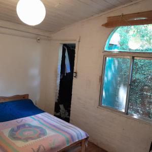 インヘニェロ・マスチュウイツにあるCasa quinta con pileta en Maschwitzのベッドと窓のある小さな寝室 +9枚の写真
