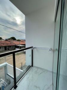 a glass balcony with a view of the water at Flats do Lucca in Tamandaré