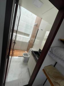 a small bathroom with a toilet and a sink at Flats do Lucca in Tamandaré