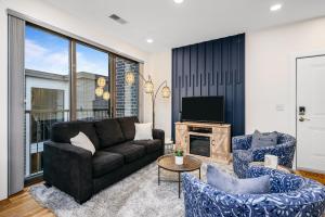 a living room with a couch and chairs and a tv at Urban Escape in Downtown Traverse City in Traverse City