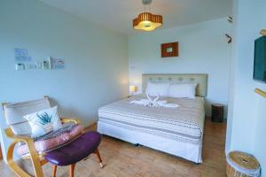 a bedroom with a large bed and a chair at Jamjuree Home at Udonthani in Udon Thani