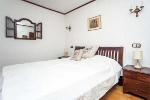 モライラにあるMandalaのベッドルーム(白いベッド1台、鏡付きドレッサー付)