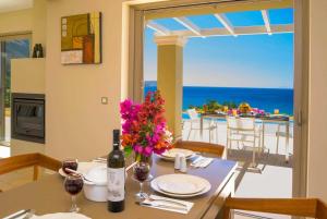 a dining room with a table with a bottle of wine at Trapezaki Beach in Trapezaki