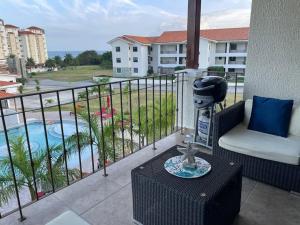 balcón con silla y vistas a la piscina en Beautiful Apartment in Vista Mar Golf, Beach & Marina, en Santa Teresita