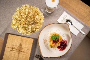 einen Tisch mit einem Teller Essen und einem Getränk in der Unterkunft Hotel OTP Birkenhof in Bad Kleinkirchheim