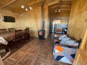 a living room with a woodburning stove in a cabin at Cabañas y Tinajas Rio Quenuir in Maullín