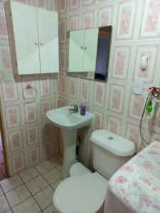 ein Badezimmer mit einem Waschbecken, einem WC und einem Spiegel in der Unterkunft Cabañas Matanzas Noemi in Boca Pupuya