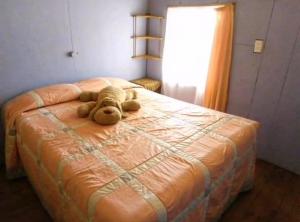 a teddy bear laying on top of a bed at Cabañas Matanzas Noemi in Boca Pupuya