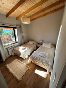 1 dormitorio con 2 camas y ventana en Patagonia en Trevelin