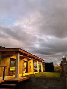 una pequeña casa con un cielo nublado detrás de ella en Patagonia en Trevelin