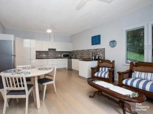 een keuken en een woonkamer met een tafel en stoelen bij Swanky Suite Studio in Mannering Park