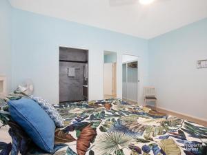 een slaapkamer met een bed met een kleurrijk dekbed bij Swanky Suite Studio in Mannering Park