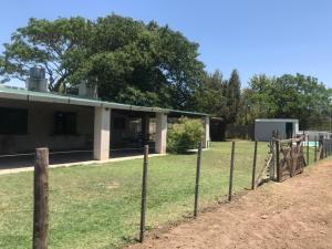 einen Zaun vor einem Gebäude in der Unterkunft Casa rural familiar con pileta elrejunte in Arrecifes