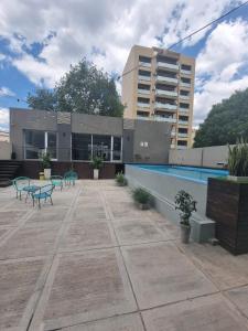 a patio with a swimming pool and a building at BEM Apartamento in Salta