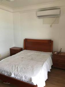 1 dormitorio con 1 cama con cabecero de madera y vestidor en Beira mar, en Guarapari