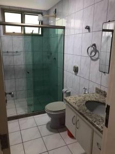 y baño con ducha, aseo y lavamanos. en Beira mar, en Guarapari