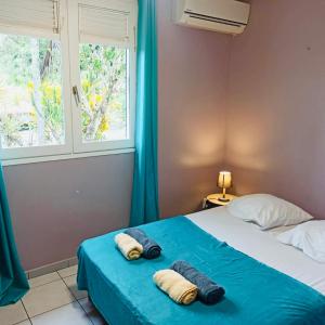 una camera da letto con un letto con lenzuola blu e una finestra di Villa TrÔpik Diamond + Bungalow a Le Diamant