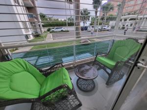 uma varanda com 2 cadeiras, uma mesa e uma janela em Hermoso y comodo apartamento em Santiago de los Caballeros
