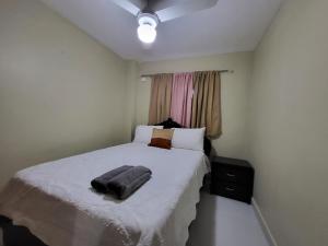 una camera da letto con un letto e un asciugamano sopra di Hermoso y comodo apartamento a Santiago de los Caballeros