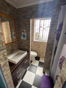 a bathroom with a sink and a toilet and a mirror at Casa cercana a playa Los Vilos in Los Vilos