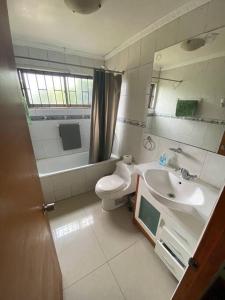 a bathroom with a sink and a toilet and a mirror at Casa cercana a playa Los Vilos in Los Vilos
