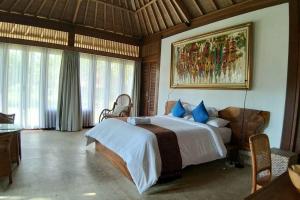 Villa & Farm for 5, near Sidemen w/ Mt. Agung View في Selat: غرفة نوم بسرير كبير مع وسائد زرقاء