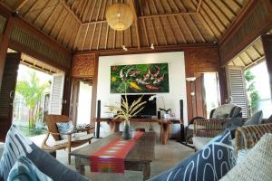 Villa & Farm for 5, near Sidemen w/ Mt. Agung View في Selat: غرفة معيشة مع طاولة وكراسي خشبية
