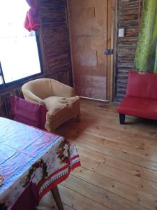 ein Wohnzimmer mit einem Sofa und einem Stuhl in der Unterkunft el gitano feliz in Laguna Verde