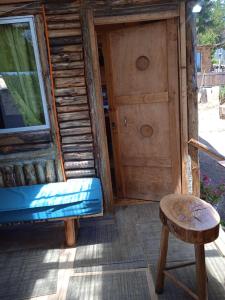 uma cabana de madeira com uma porta e um banco em el gitano feliz em Laguna Verde