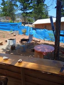 einen Holzzaun mit einem Picknicktisch und einem Zelt in der Unterkunft el gitano feliz in Laguna Verde