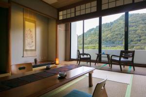 Pokój ze stołem i krzesłami oraz dużym oknem w obiekcie Koderaso w mieście Himeji