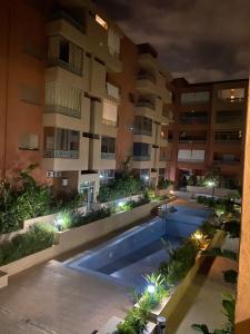 马拉喀什Appartement a loué pour les familles的一座公寓楼,晚上设有游泳池