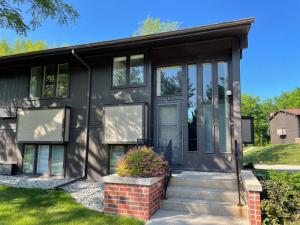 een zwart huis met een voordeur en ramen bij Newly Remodeled Mid-Century Modern Lake Condo in Lake Geneva