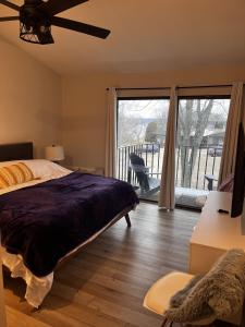 a bedroom with a bed and a view of a balcony at Newly Remodeled Mid-Century Modern Lake Condo in Lake Geneva