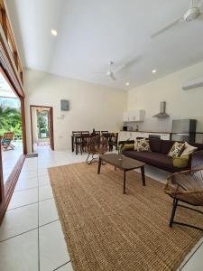 ein Wohnzimmer mit einem Sofa und einem Tisch in der Unterkunft Villa Meranti - Spacious Private Pool Villa in Pantai Cenang
