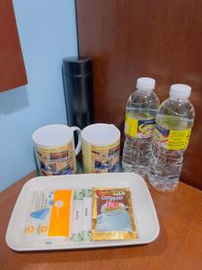 a tray with a book and two bottles of water at Noor Boutique Hotel in Kuala Perlis