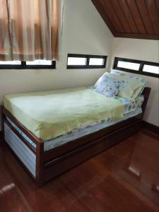een groot bed in een kamer met 2 ramen bij Baguio Rest House in Baguio