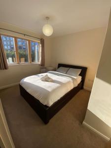 um quarto com uma cama grande e lençóis brancos em 2 bedroom apartment city centre Birmingham em Birmingham