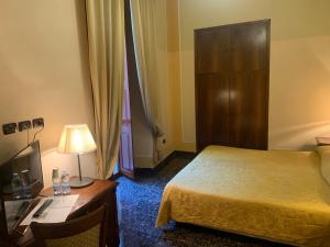 une chambre d'hôtel avec un lit, un bureau et une lampe dans l'établissement Le Stanze Del Vicerè Boutique Hotel, à Naples