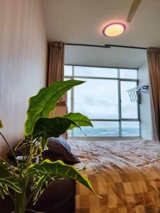 a bedroom with a large green plant next to a bed at Castle House Johor Bahru UTM in Johor Bahru