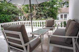 2 Stühle und ein Tisch und ein Sonnenschirm auf dem Balkon in der Unterkunft Sultani Hotel in Kinshasa